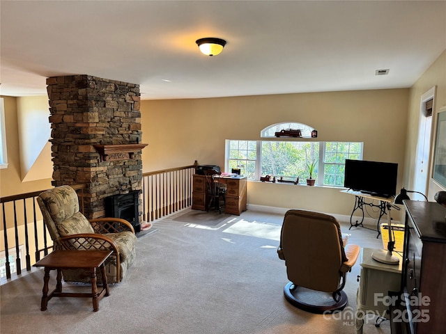 office area featuring baseboards, a stone fireplace, visible vents, and light colored carpet