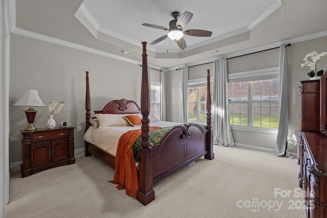 bedroom with light carpet, baseboards, a tray ceiling, and ornamental molding