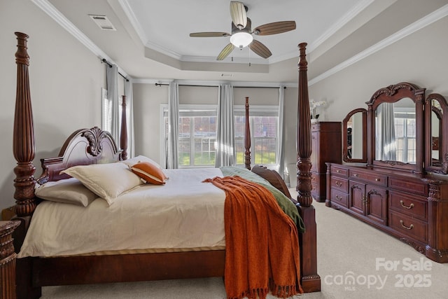 bedroom featuring visible vents, a raised ceiling, a ceiling fan, light colored carpet, and crown molding