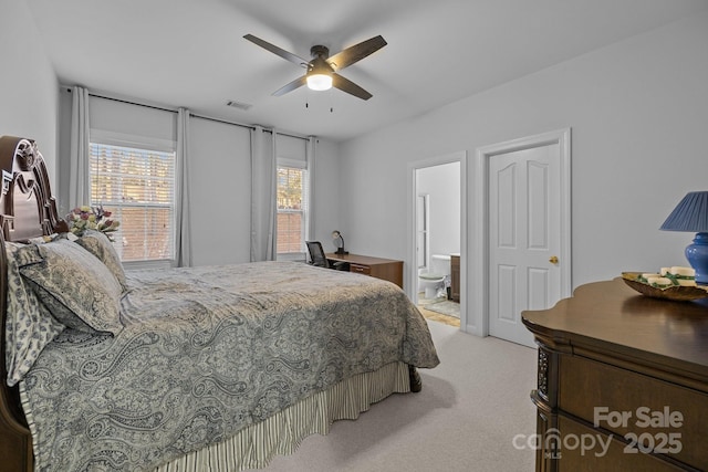 bedroom featuring ensuite bath, visible vents, a ceiling fan, and light colored carpet