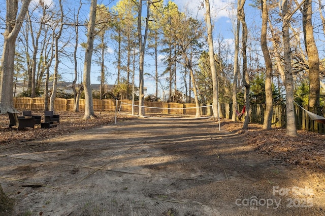 view of yard featuring volleyball court and fence