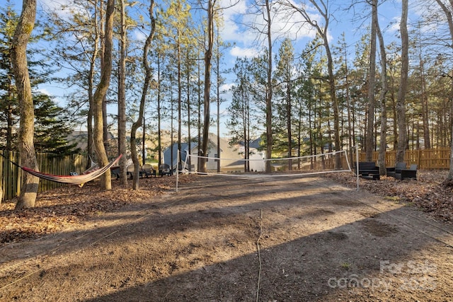 view of yard with fence and volleyball court