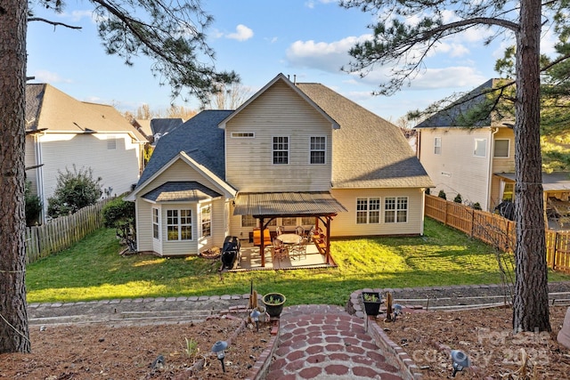 rear view of house with a yard, a patio area, and a fenced backyard