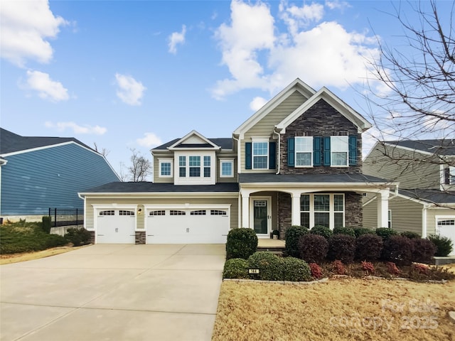 craftsman-style home with a garage, stone siding, and concrete driveway