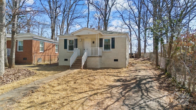 view of front of property featuring crawl space, brick siding, and fence