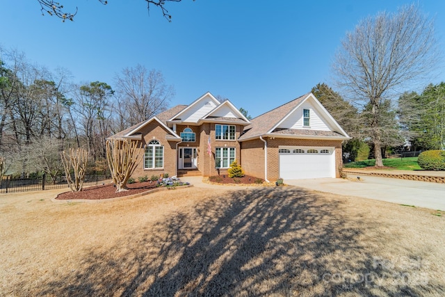 view of front of property with brick siding, driveway, a garage, and fence