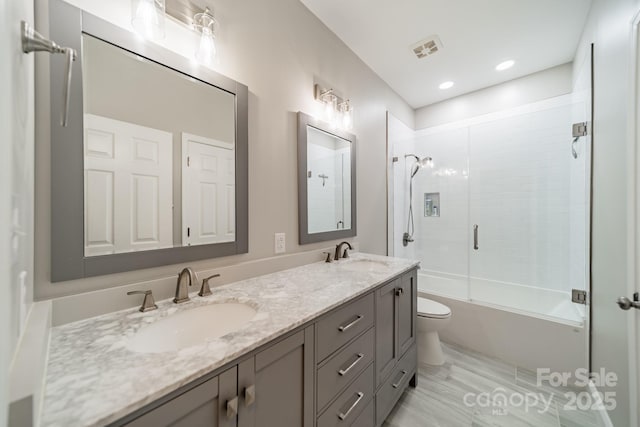 bathroom with a sink, visible vents, toilet, and double vanity