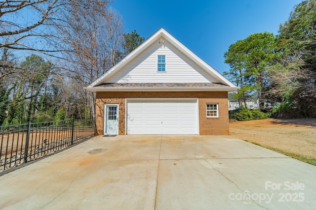 garage featuring fence and driveway