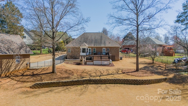 back of property featuring a deck and fence