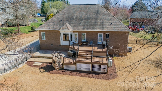 rear view of property featuring brick siding, fence, a wooden deck, cooling unit, and crawl space