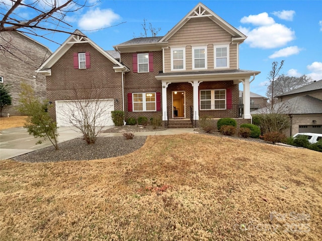 traditional-style home featuring a garage, concrete driveway, brick siding, and a porch