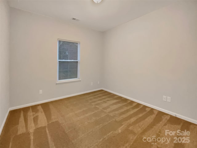 empty room with visible vents, baseboards, and carpet flooring