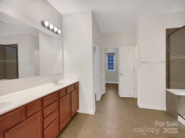 bathroom featuring double vanity, a shower, and a sink