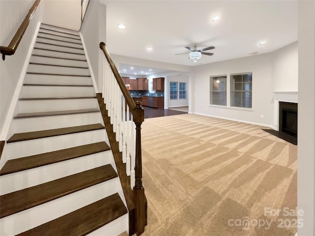 interior space with a fireplace with flush hearth, stairway, carpet flooring, and recessed lighting