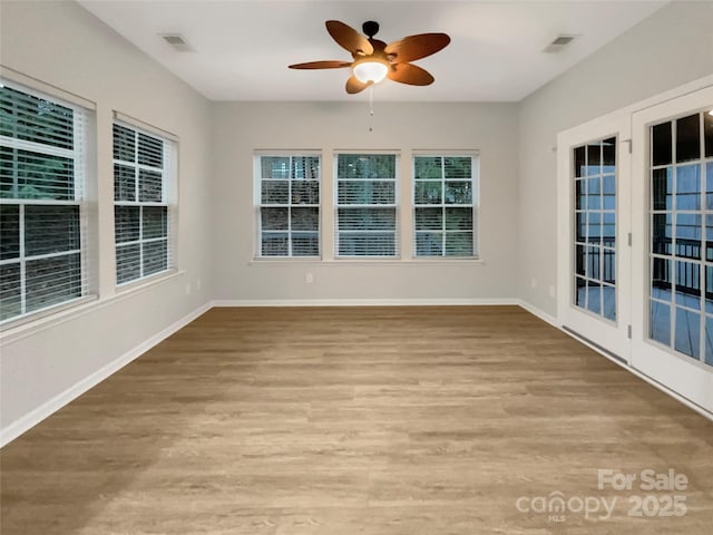 unfurnished sunroom with ceiling fan and visible vents