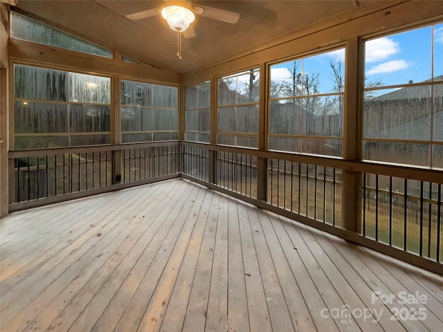 unfurnished sunroom featuring a ceiling fan and lofted ceiling