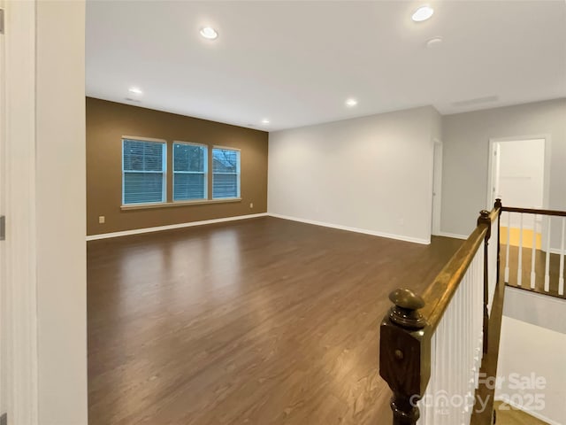 empty room featuring recessed lighting, baseboards, and wood finished floors