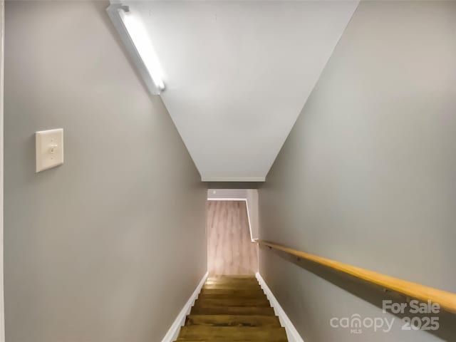 stairway featuring wood finished floors and baseboards