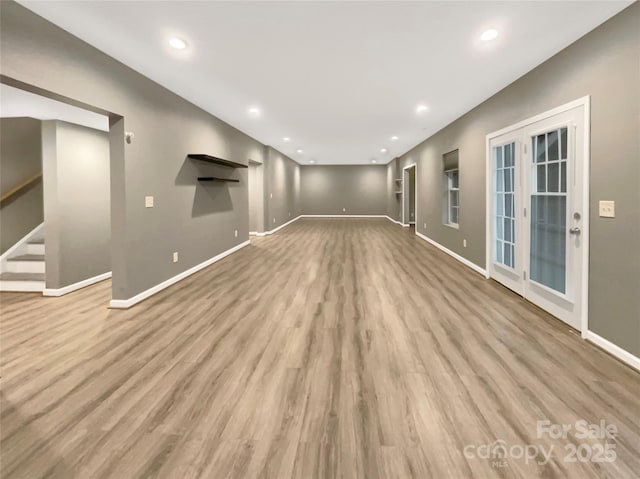 unfurnished living room featuring stairs, baseboards, wood finished floors, and recessed lighting