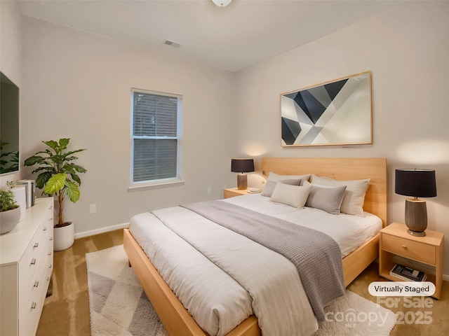 bedroom featuring baseboards and visible vents