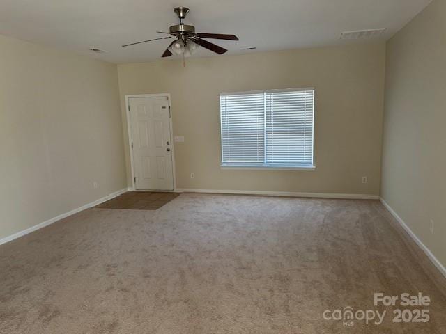 spare room with light colored carpet, ceiling fan, and baseboards