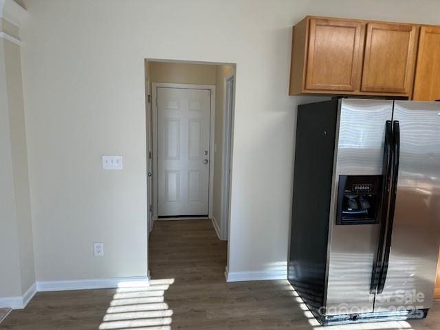 kitchen featuring stainless steel fridge, baseboards, and dark wood finished floors