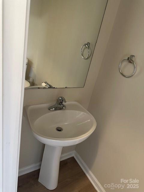 bathroom with wood finished floors and baseboards