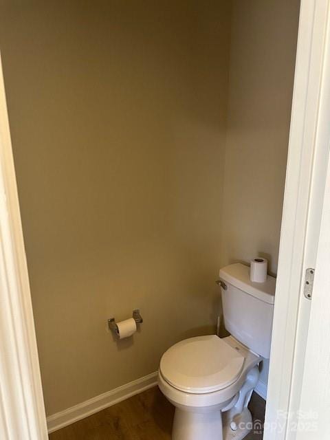 bathroom featuring toilet, baseboards, and wood finished floors