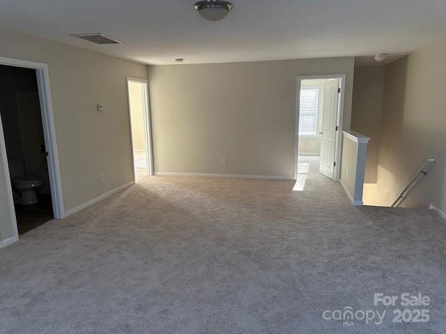 carpeted empty room with visible vents and baseboards