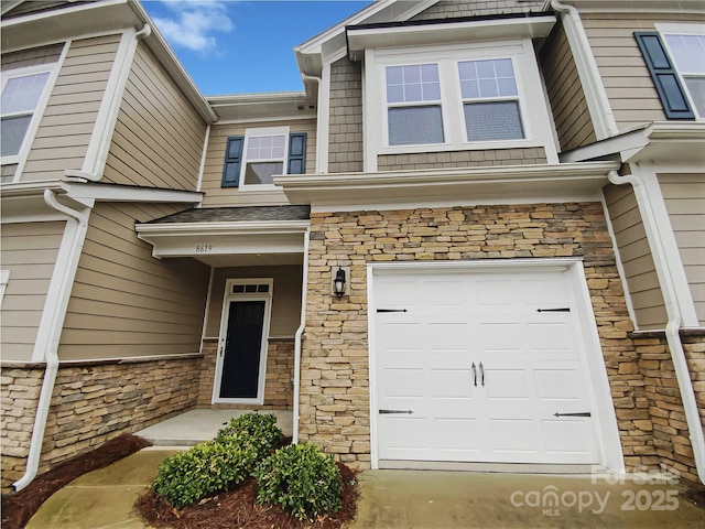 view of front facade with a garage and stone siding