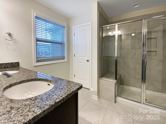 bathroom with a stall shower, tile patterned flooring, and vanity