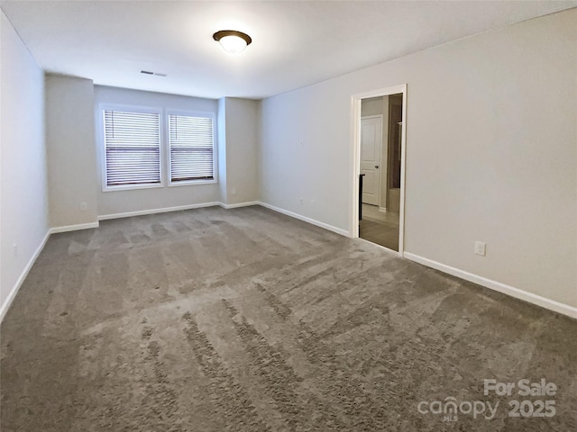 unfurnished room featuring carpet floors, visible vents, and baseboards