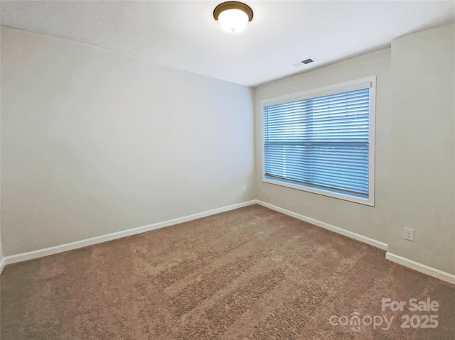 unfurnished room featuring carpet floors, visible vents, and baseboards