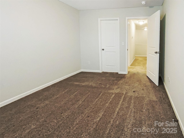 unfurnished bedroom with carpet flooring and baseboards