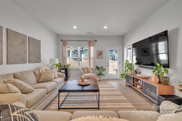living area featuring light wood-type flooring, visible vents, and recessed lighting