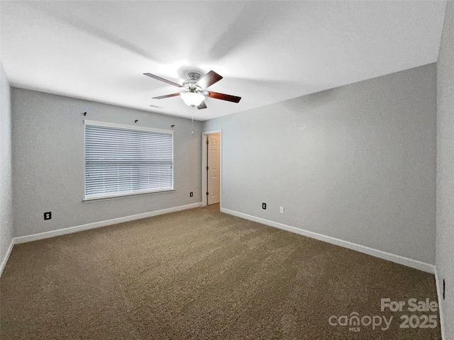 carpeted empty room featuring ceiling fan and baseboards