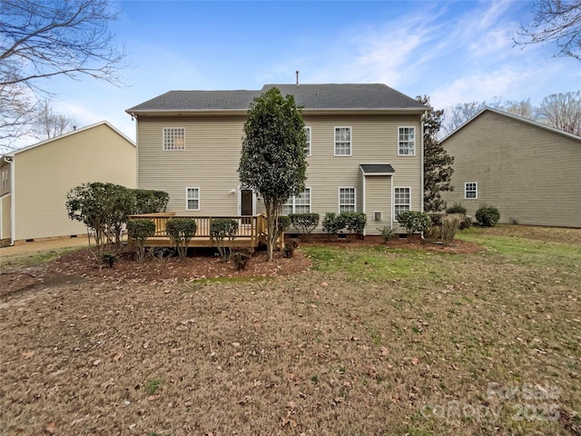 rear view of property featuring crawl space, a yard, and a wooden deck