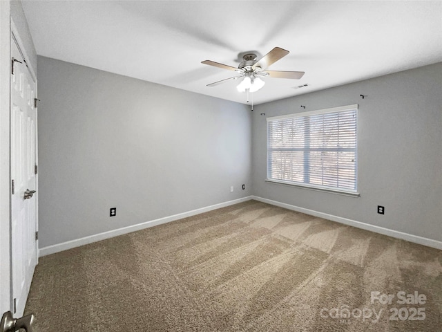 empty room featuring baseboards, visible vents, a ceiling fan, and light colored carpet