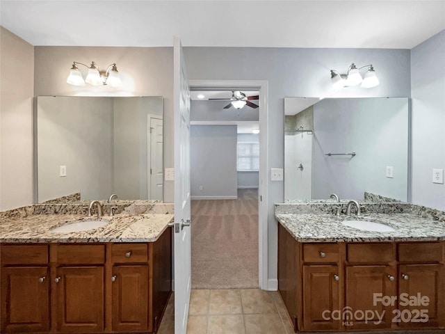 bathroom featuring a ceiling fan, two vanities, and a sink