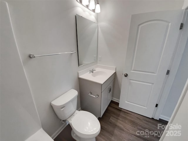 bathroom featuring vanity, toilet, and wood finished floors