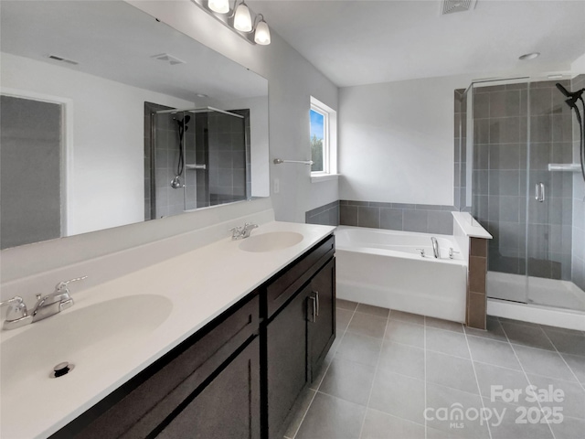 full bathroom with a garden tub, tile patterned flooring, a sink, and a stall shower