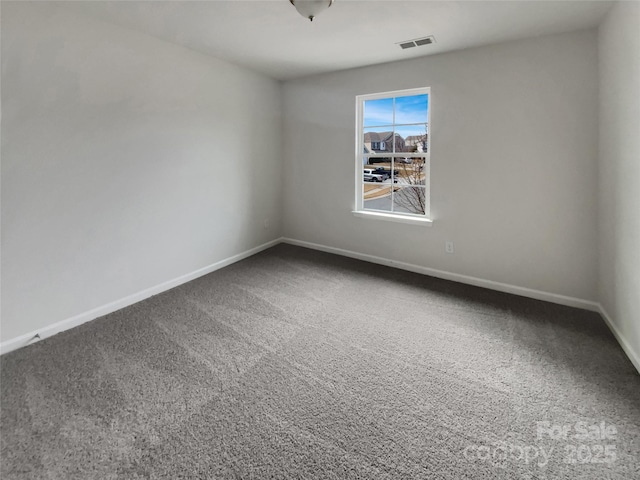 spare room featuring carpet flooring, visible vents, and baseboards