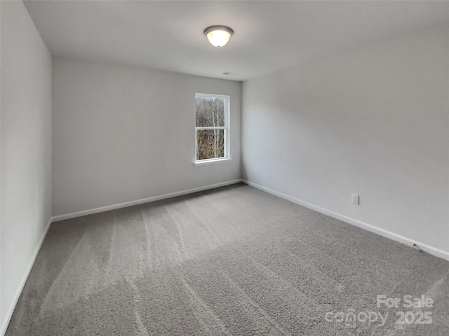 unfurnished room featuring baseboards and carpet flooring