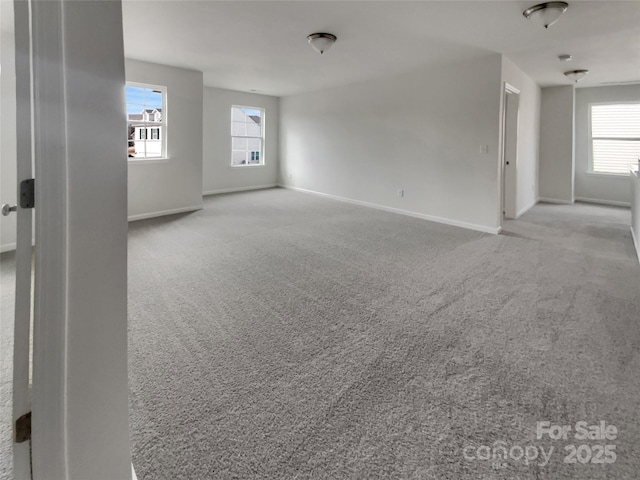 empty room featuring light carpet and baseboards