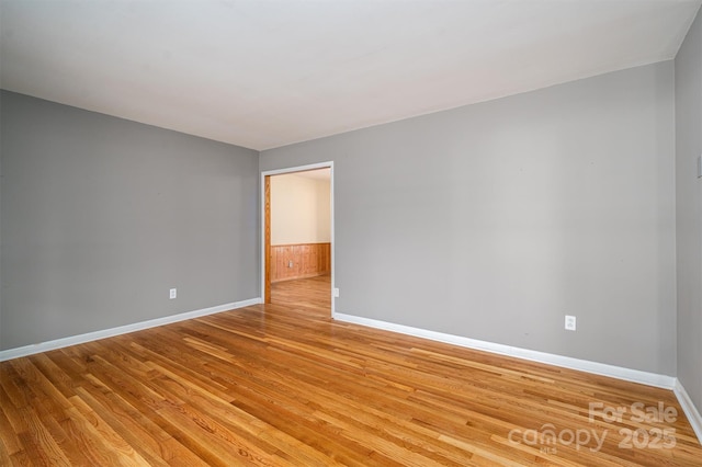 empty room with light wood-style flooring and baseboards