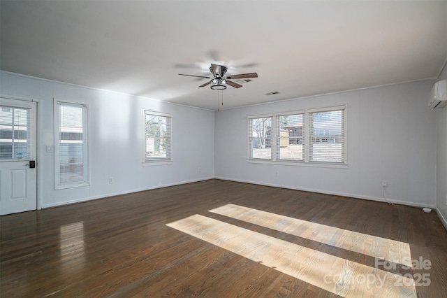 empty room featuring baseboards, visible vents, a ceiling fan, a wall unit AC, and dark wood-style flooring