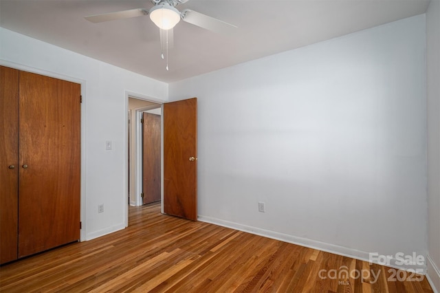 unfurnished bedroom with light wood finished floors, ceiling fan, baseboards, and a closet