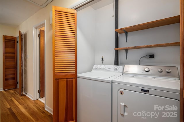 washroom with washer and dryer, laundry area, and light wood finished floors