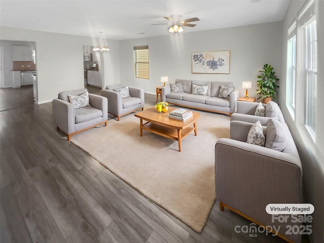 living room featuring ceiling fan, baseboards, a wealth of natural light, and wood finished floors