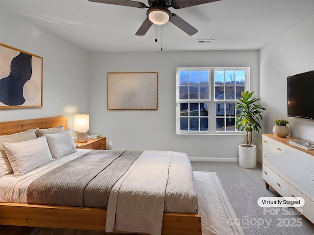 carpeted bedroom with a ceiling fan, visible vents, and baseboards